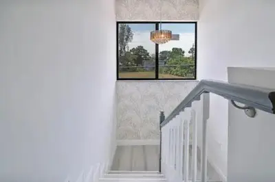 a white staircase with a window and a chandelier at New Townhome near Wilton/Las Olas/Beach in Fort Lauderdale