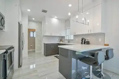 a large white kitchen with a counter and appliances at New Townhome near Wilton/Las Olas/Beach in Fort Lauderdale