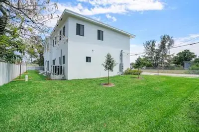 a large white building with a grass yard at New Townhome near Wilton/Las Olas/Beach in Fort Lauderdale
