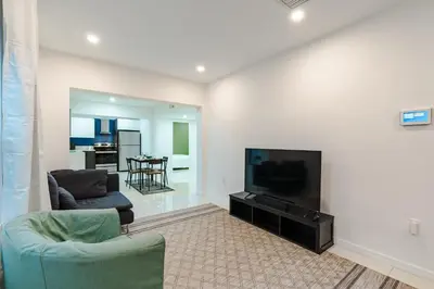 a living room with a flat screen tv and a couch at Beautiful, fully furnished 2bed 1bath house - 5 minute walk to Miracle Mile Downtown Coral Gables in Miami