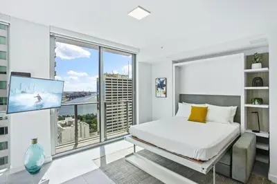 a white bedroom with a bed and a large window at - Casiola Studio's - near Cruise Terminal, Bayfront Park and Kaseya Center in Miami