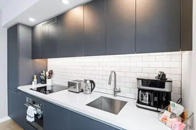 a kitchen with black cabinets and a sink at - Casiola Studio's - near Cruise Terminal, Bayfront Park and Kaseya Center in Miami