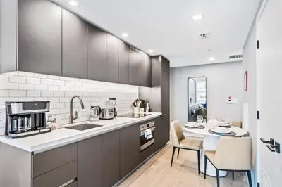 a kitchen with a sink and a table with chairs at - Casiola Studio's - near Cruise Terminal, Bayfront Park and Kaseya Center in Miami