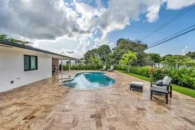a swimming pool in the backyard of a house at Sandals Beach Cottage in Fort Lauderdale