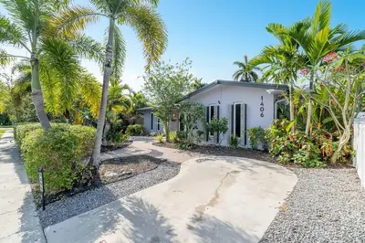 a house with palm trees in front of it at Hollys Hacienda with Heated Pool and Patio Area in Hollywood