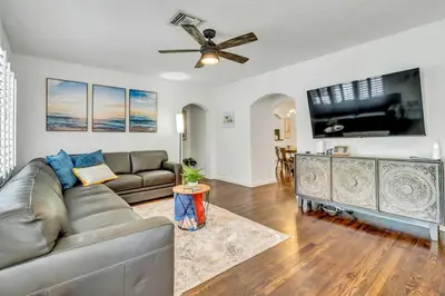 a living room with a couch and a flat screen tv at Victoria Park Oasis with Heated Pool and More in Fort Lauderdale