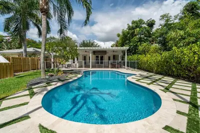 a swimming pool in the backyard of a house at Victoria Park Oasis with Heated Pool and More in Fort Lauderdale