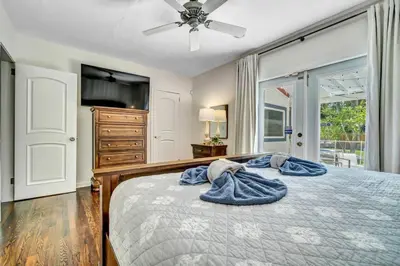 a bedroom with a bed with a ceiling fan and a dresser at Victoria Park Oasis with Heated Pool and More in Fort Lauderdale