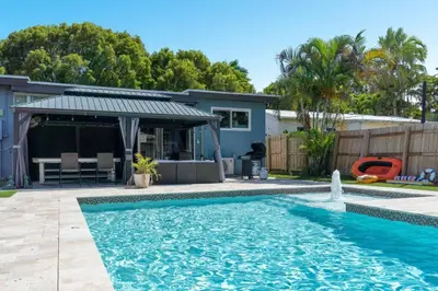 a swimming pool in front of a house at Wileys Paradise Three Bedroom Two Bath plus Office and Heated Pool in Hollywood