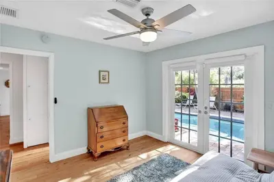 a living room with a ceiling fan and a dresser at Chic Victoria Park Villa with Heated Pool and Spa in Fort Lauderdale