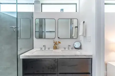 a bathroom with two sinks and two mirrors at Lux Villa with Pool, Wynwood House by RoveTravel in Miami
