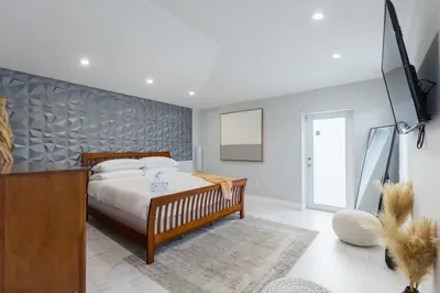a bedroom with a bed and a dresser in it at Olas Villa by Rove Travel - Home with Heated Pool in Fort Lauderdale