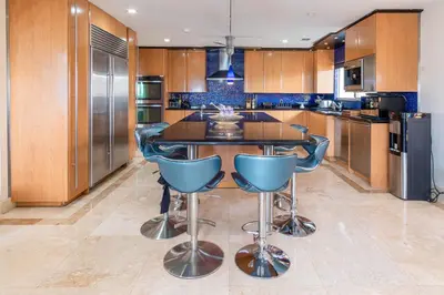 a kitchen with a island with blue bar stools at Oceana Blue / Beach Front / Pool / Bar / Relax in Fort Lauderdale