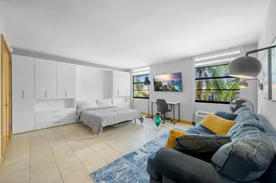 a living room with a couch and a bed at Cozy studio, walk to the beach, restaurants, bars in Miami Beach