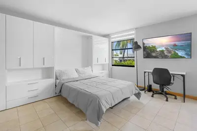 a bedroom with a bed and a desk and a chair at Cozy studio, walk to the beach, restaurants, bars in Miami Beach