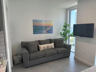 a living room with a couch and a flat screen tv at Exceptional Studio with King Bed and Queen Sofa-bed in Miami