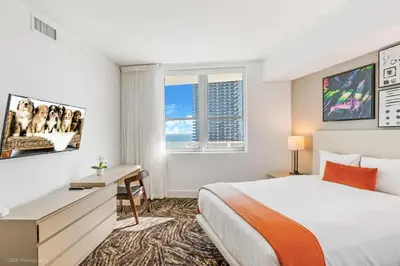 a bedroom with a bed and a desk and a window at Ocean Front Paradiiise 3 Bedroom by Zen in Hollywood