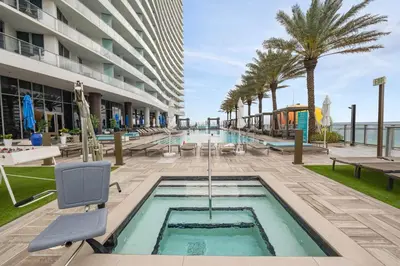 a pool at a hotel with palm trees and a building at Ocean Front Paradiiise 3 Bedroom by Zen in Hollywood