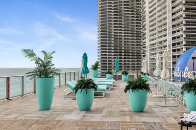 a balcony with chairs and umbrellas on the beach at Ocean Front Paradiiise 3 Bedroom by Zen in Hollywood