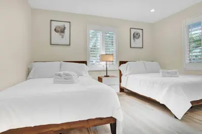 two beds in a bedroom with white walls at Modern 4BR Villa with Pool - Outdoor amenities - WFH in Fort Lauderdale