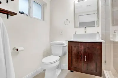 a bathroom with a toilet and a sink and a mirror at Modern 4BR Villa with Pool - Outdoor amenities - WFH in Fort Lauderdale