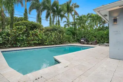 a swimming pool in a backyard with palm trees at Modern 4BR Villa with Pool - Outdoor amenities - WFH in Fort Lauderdale