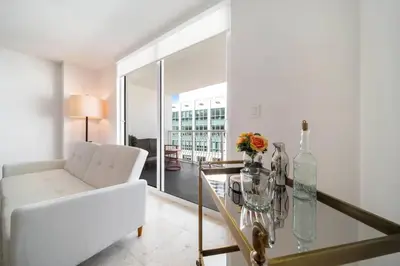 a living room with a white couch and a glass table at Penthouse APT w Private Balcony King Bed Parking in Miami
