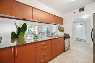 a large kitchen with brown cabinets and a sink at Penthouse APT w Private Balcony King Bed Parking in Miami
