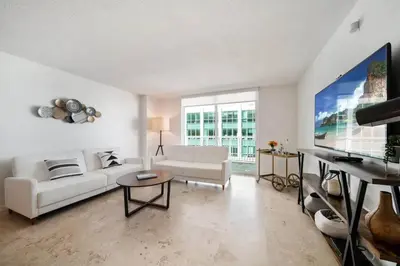 a living room with a white couch and a tv at Penthouse APT w Private Balcony King Bed Parking in Miami