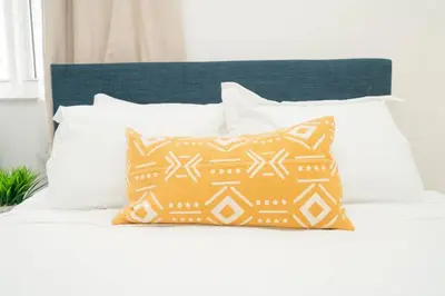 a bed with white pillows and a blue headboard at 2Bed 2 Bath Airbnb Friendly building with Pool, Hot Tub, and Gym in Miami