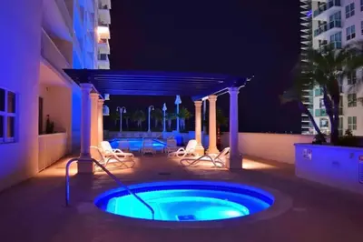 a hot tub in the middle of a patio at night at 2 Bedroom, 2 Bathroom plus Den Brickell Condo Pool, Hot Tub, and Gym in Miami