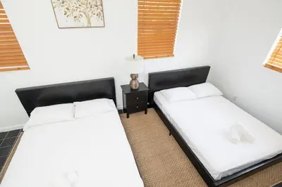 two beds sitting next to each other in a room at Modern 5 Bedroom Miami Home 15 Min to the Beach in Miami