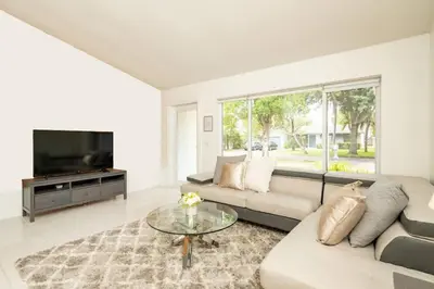 a living room with a couch and a tv at Waterfront 2-Story Villa with Heated Pool in Pembroke Pines