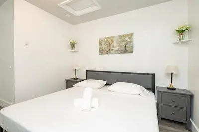 a white bedroom with a white bed and two night stands at Waterfront 2-Story Villa with Heated Pool in Pembroke Pines