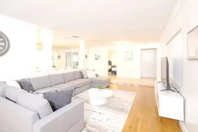 a white living room with a couch and a tv at Stunning Lake-Front Villa with Pool & Spa in Pembroke Pines
