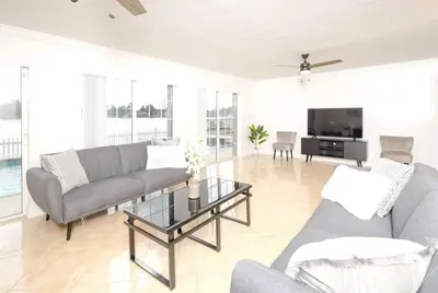 a living room with a couch and a tv at Stunning Lake-Front Villa with Pool & Spa in Pembroke Pines