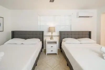 two beds sitting next to each other in a bedroom at Beautiful 7-Bedroom Villa with Pool in Hialeah