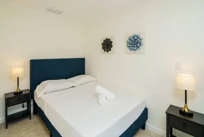 a bedroom with a bed with two night stands and two lamps at Beautiful 7-Bedroom Villa with Pool in Hialeah