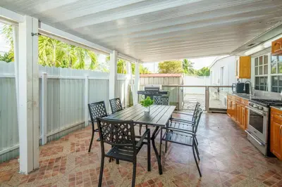 a kitchen with a table and chairs on a patio at Beautiful 7-Bedroom Villa with Pool in Hialeah
