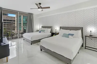 a hotel room with two beds and a balcony at Deluxe 1 BR suite with Pool, Parking, Balcony and Ocean Views in Miami