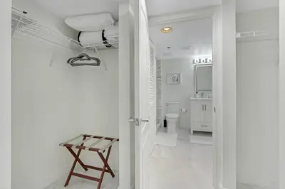 a white bathroom with a toilet and a stool at Deluxe 1 BR suite with Pool, Parking, Balcony and Ocean Views in Miami