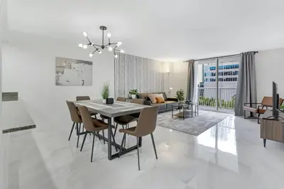 a dining room and living room with a table and chairs at Deluxe 1 BR suite with Pool, Parking, Balcony and Ocean Views in Miami