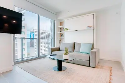 a living room with a couch and a table at Modern and newly built studio with Pool, Gym, and Restaurant access in Miami