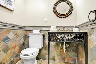 a bathroom with a toilet and a mirror at Lux 2BR Condo in Ocean Reserve with Pools and Tennis Courts in Miami Beach
