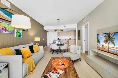 a living room with a couch and a dining room at Ocean View Balcony, Beachfront Resort, Pools, Gym in Hollywood