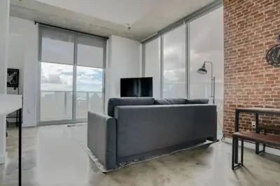 a living room with a couch and a brick wall at Sun-Splashed 1BR Condo unit in DWTN Miami with WFH in Miami