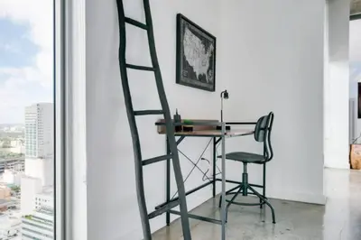 a ladder leaning against a desk in a room with a window at Sun-Splashed 1BR Condo unit in DWTN Miami with WFH in Miami