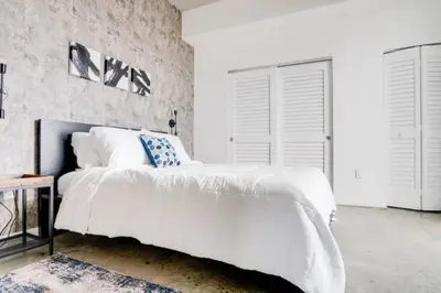 a bedroom with a large white bed and white walls at Sun-Splashed 1BR Condo unit in DWTN Miami with WFH in Miami