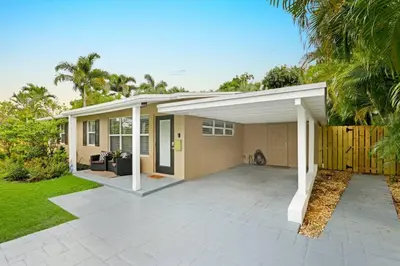 a detached house with a garage in a yard at Modern 2BRHouse in Wilton Manors with a Heated Pool and KING Bed in Fort Lauderdale