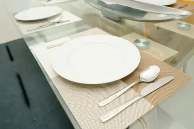 a white plate sitting on a glass table with silverware at LuxBright 1BR Brickell Paradise with Oceanview and Parking in Miami